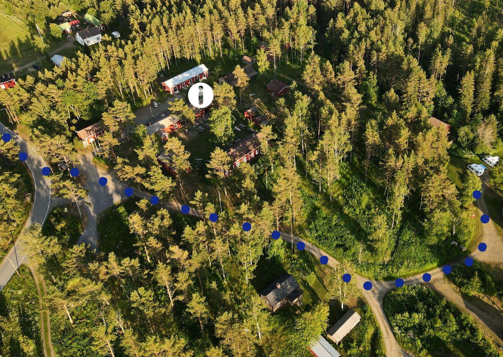 Flygfoto över Kilens hembygdsgård med museibyggnader, naturstig och skog
