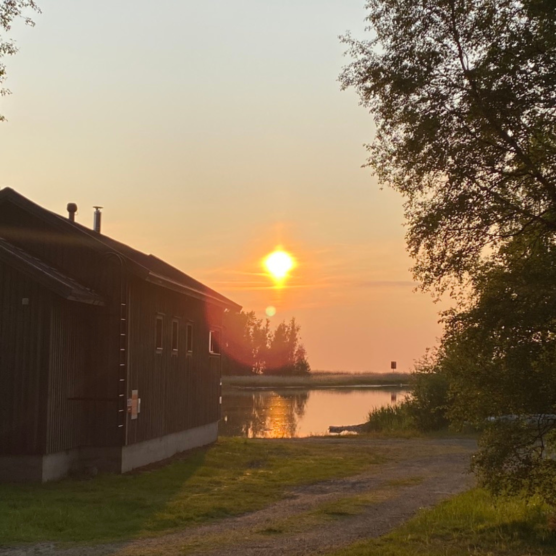 Solnedgång vid bastun på Kilen, med varmt kvällsljus över viken