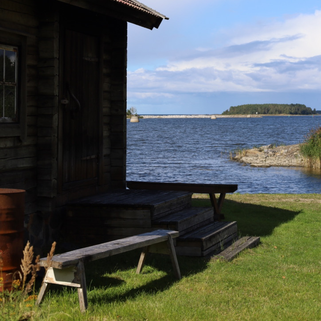 Träbyggnad vid stranden med utsikt över havet och öar vid Kilen