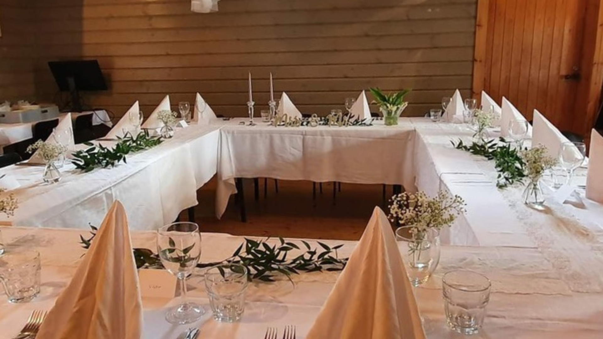 Festdukning med vita dukar, servetter och gröna bladdekorationer i Kilens kabinett.