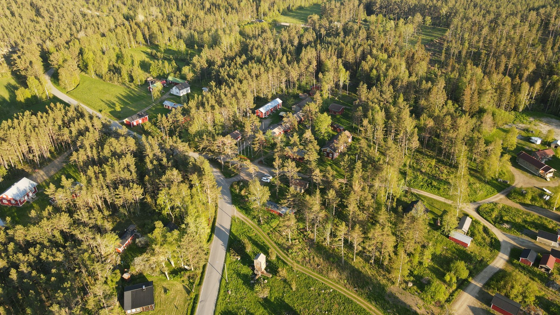 Flygbild över Kilens hembygdsgård och omgivande skog och byggnader i Sideby.