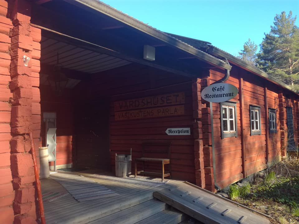 Starckes hus – röd timmerbyggnad med reception och caférestaurangskyltar.
