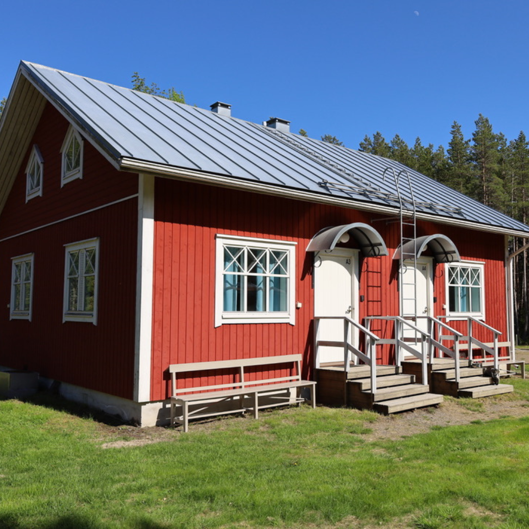 Kilenin vierastalo – perinteinen punainen rakennus metsän ja meren läheisyydessä.